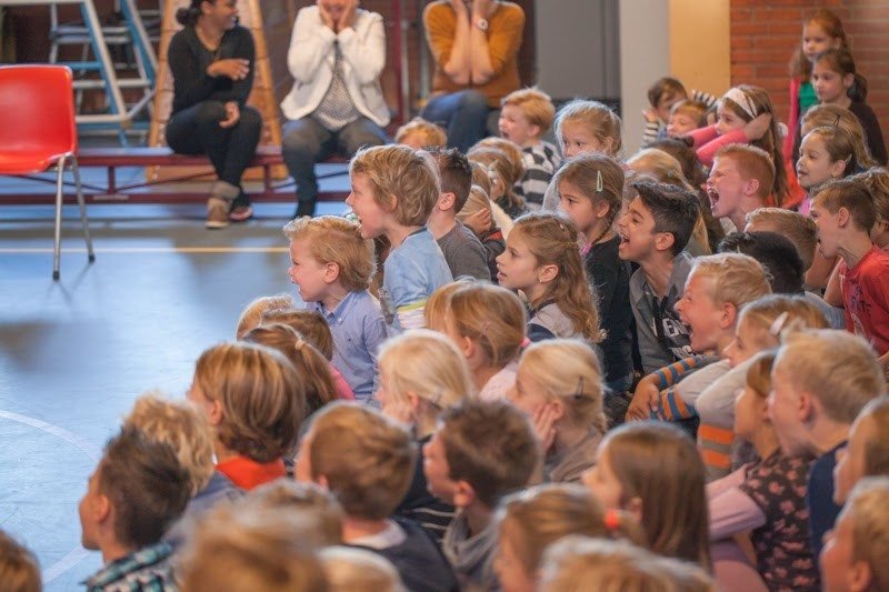 Kinderen kijken met open mond vol verwondering naar de goochelshow