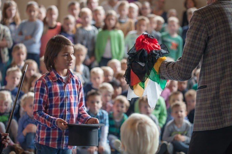 Goochelshow voor een volle gymzaal tijdens een schoolvoorstelling