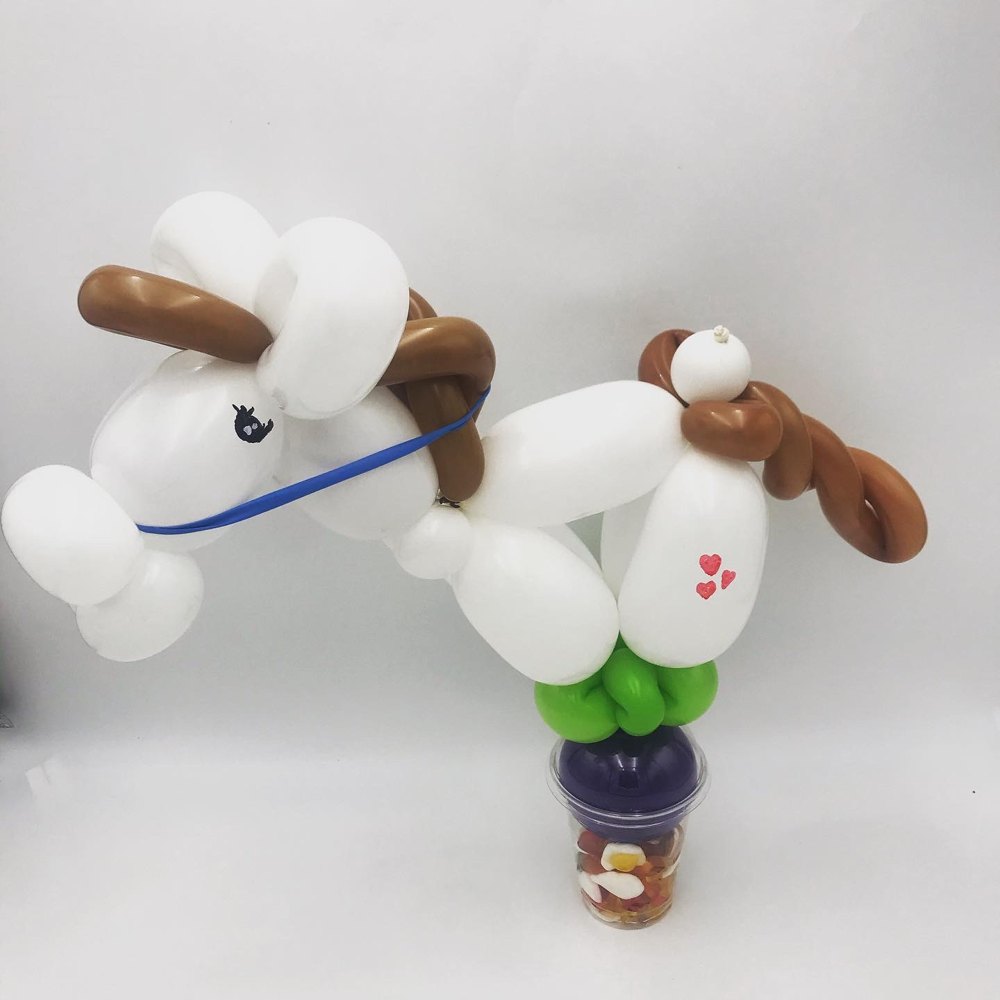 Ballonkunstwerk van een paard op een beker vol snoep