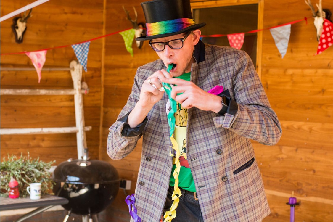 Lange Jan de Trucjesman blaast een ballon op tijdens een feestje
